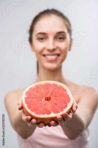 Young woman with grapefruit cut in half, healthy life concept photo