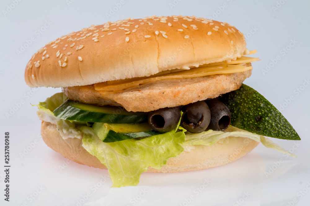 cheeseburger with beef cutlet, bacon, tomatoes and cheese slices, seasoned with sauce and green salad for a restaurant menu on a white isolated background