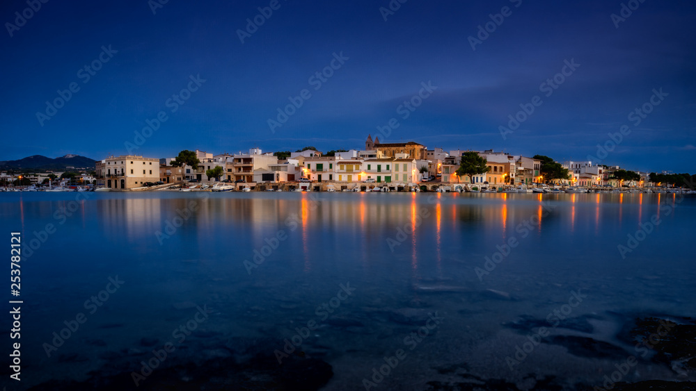 Porto Colom, mallorca, town reflecting in calm Mediterranean sea