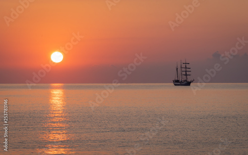 Sail ship off the coast of Mallorca anchored in the Mediterranean sea at sunrise.