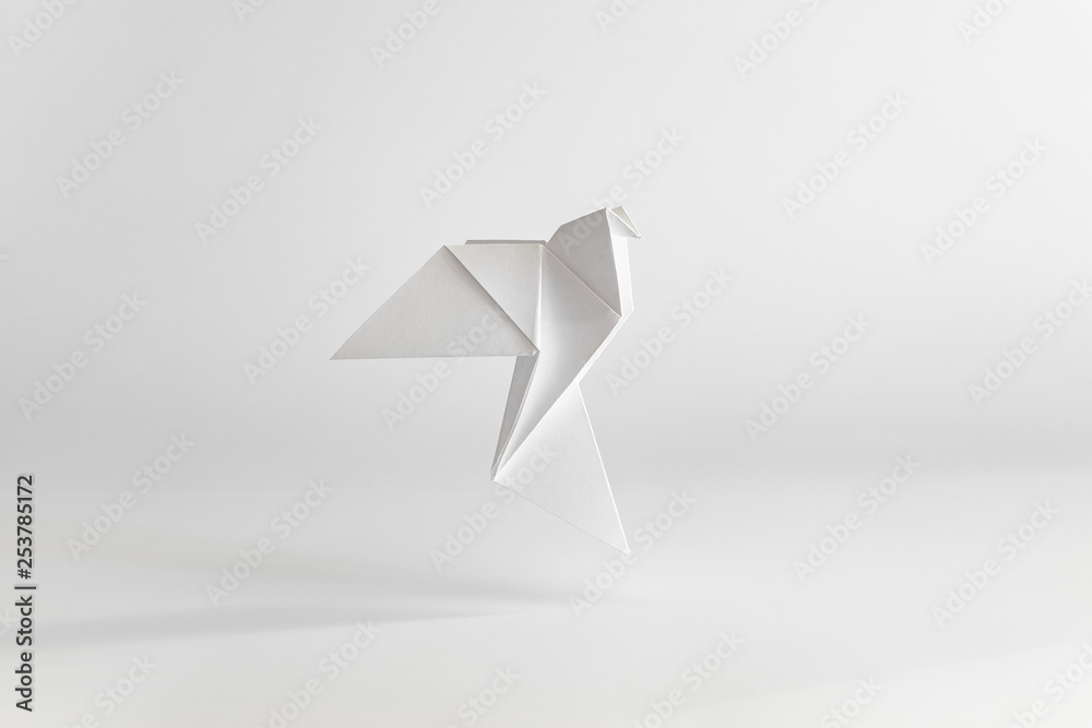 Origami dove made of white paper on white background. Minimal concept. - obrazy, fototapety, plakaty 