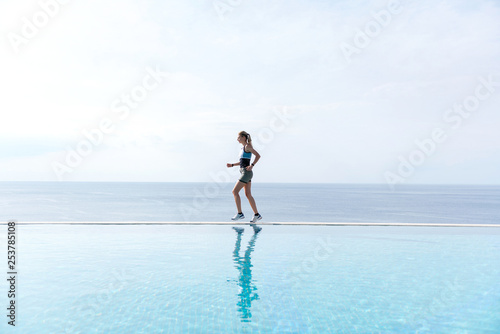 girl runs along the pool. morning running
