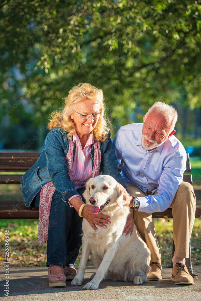 Happy Senior couple outdoors with dog enjoying