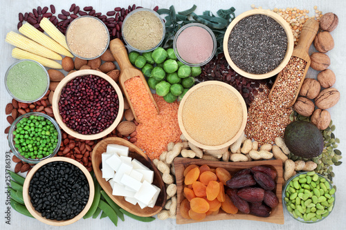 Health food high in protein with bean curd, fresh vegetables, legumes, fruit, grains, supplement powders, seeds and nuts. Super foods high in dietary fibre, vitamins and antioxidants. Top view.