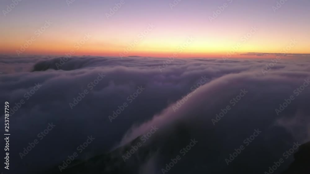 Beautiful drone view of mountains covered in clouds with a scenic sunset in the background, Australia. Beautiful drone view of mountains covered in clouds with a scenic sunset in the background, Australia.