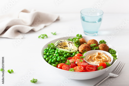 healthy vegan lunch bowl with falafel hummus tomato avocado peas