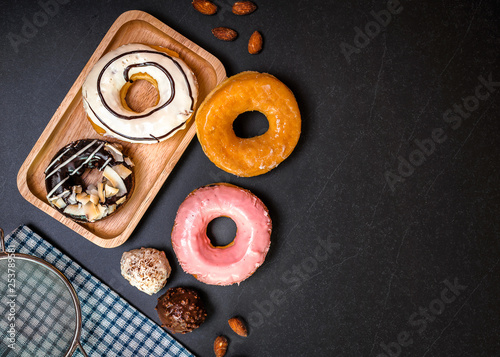 Donuts and wood on stone table.