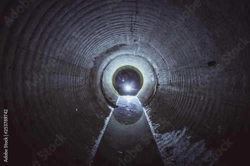 Flooded round underground drainage sewer tunnel with dirty sewage water photo