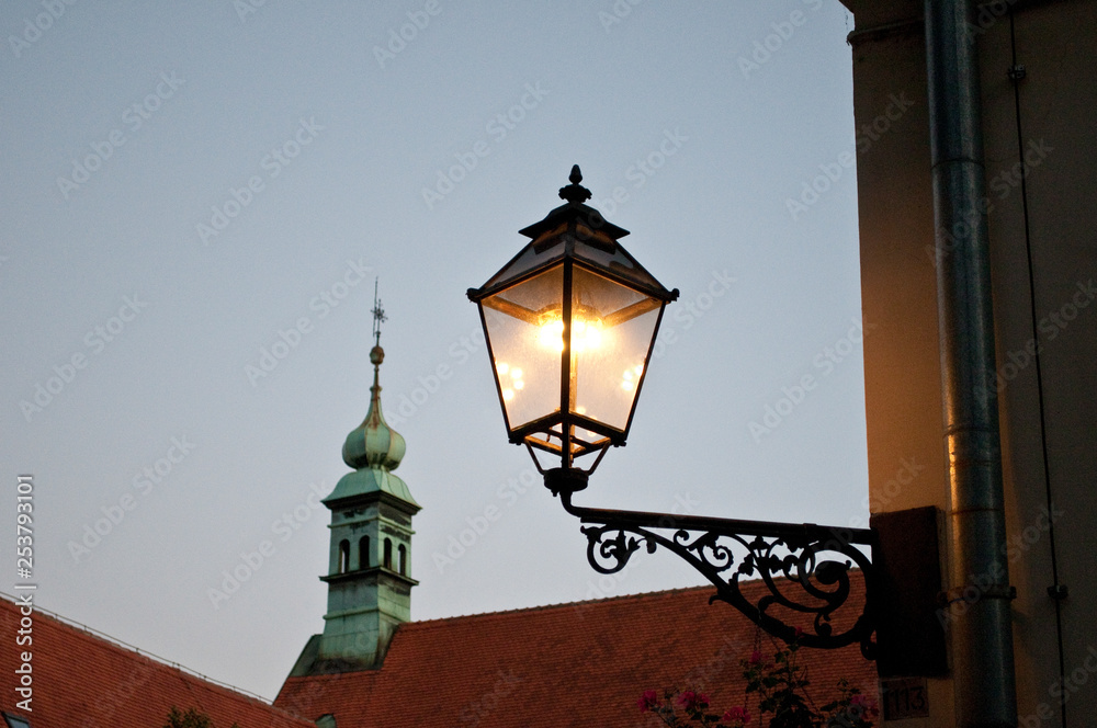 Lit lantern and church spire, Old Town, Zagreb, Croatia