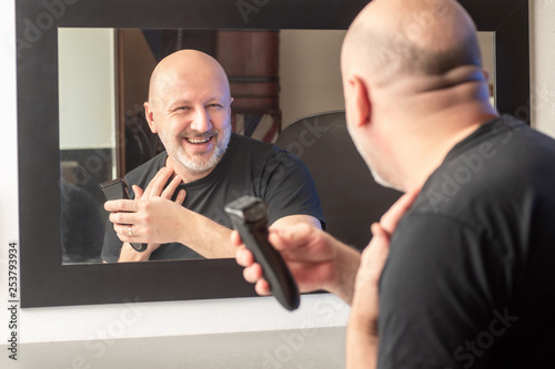 A man shaves in front of a ...