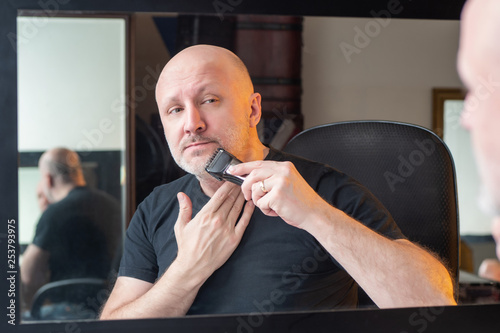 A man shaves in front of a ...