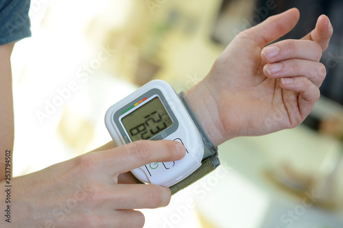 Bilde på lerret Patient with sphygmomanometer measures blood pressure at home