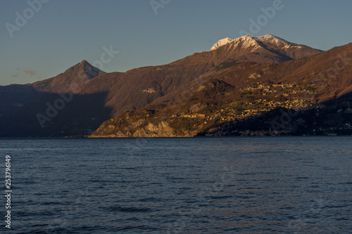 Italy, Lecco, Lake Como, a large body of water with a mountain in the background © SkandaRamana