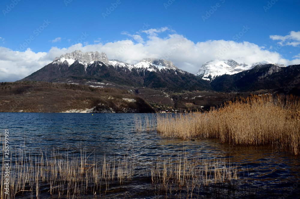 Annecy lake and snow on mountains, winter landscape in Savoy, France