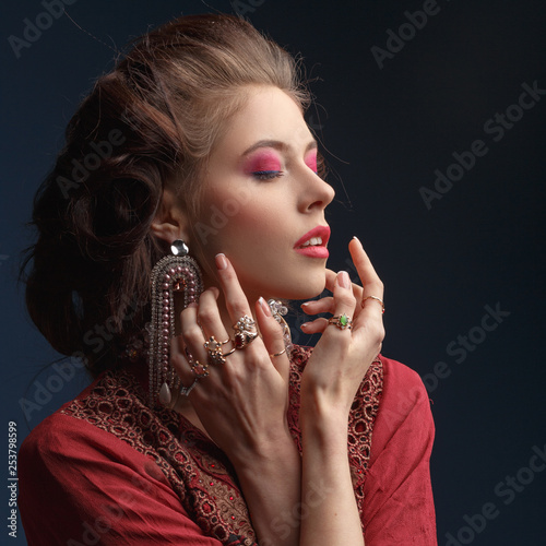 Beautiful young girl with jewelry . Woman in a necklace with a ring  earrings and a bracelet. Beauty and accessories.