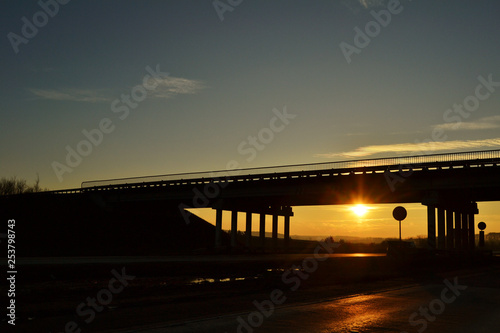 Obraz na płótnie road across the bridge at sunset w salonie