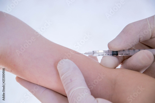 Hand with syringe for injection. Vaccination against influenza and virus. Insulin syringe with thin needle. The baby is ready for vaccination.