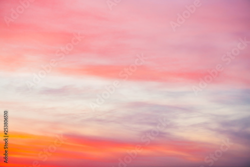 Sunset sky with pink orange light clouds. Colorful smooth blue sky gradient. Natural background of sunrise. Amazing heaven at morning. Slightly cloudy evening atmosphere. Wonderful weather on dawn. © Daniil