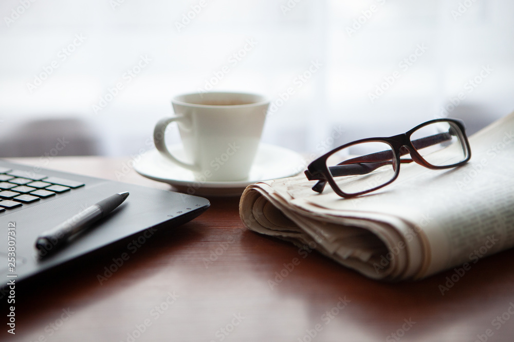 Newspaper with computer on table. Coffee break. Newspaper with computer on table. Coffee break.