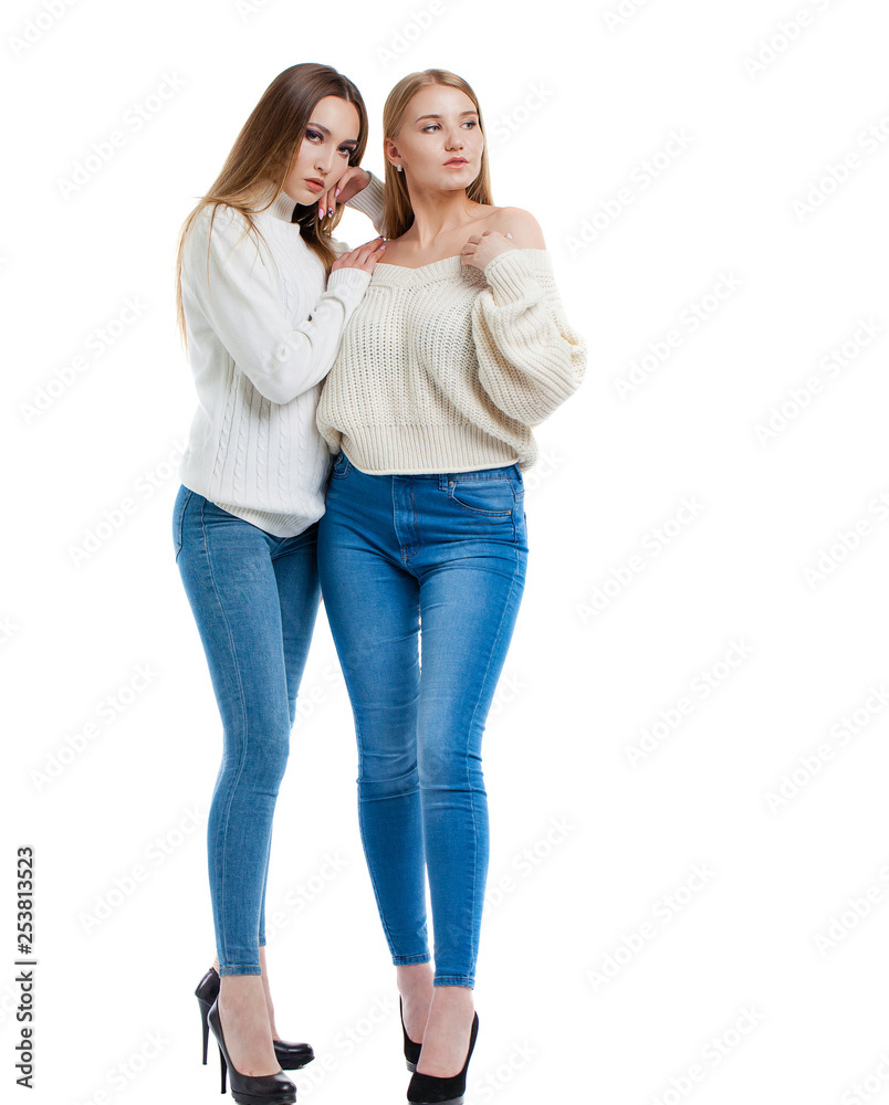 Two women in blue jeans and white sweater Two women in blue jeans and white sweater