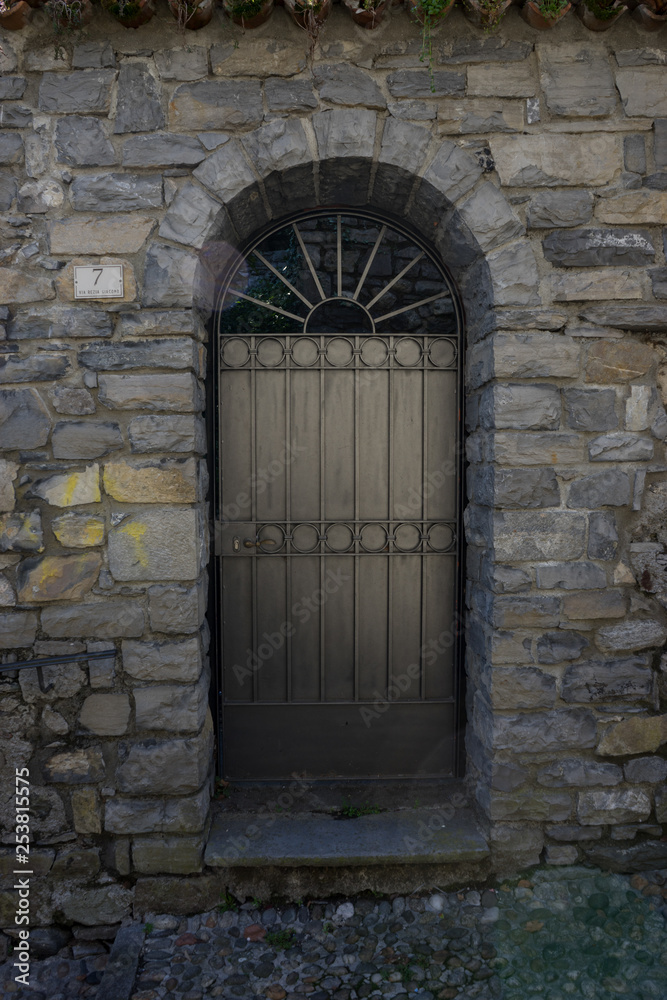 Italy, Menaggio, Lake Como, a stone building that has a black gate Italy, Menaggio, Lake Como, a stone building that has a black gate
