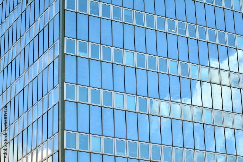 Surface of glass building with the reflection of clouds