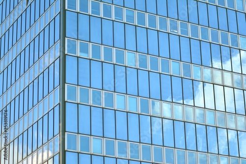 Surface of glass building with the reflection of clouds