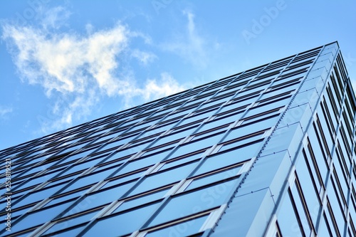 Surface of glass building with the reflection of clouds