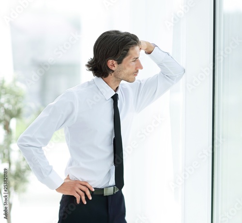 serious young businessman on background of office © yurolaitsalbert