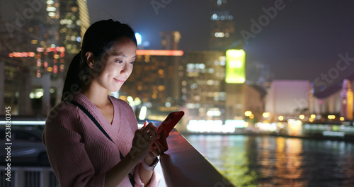 Photography Woman send sms on cellphone in Hong Kong at night