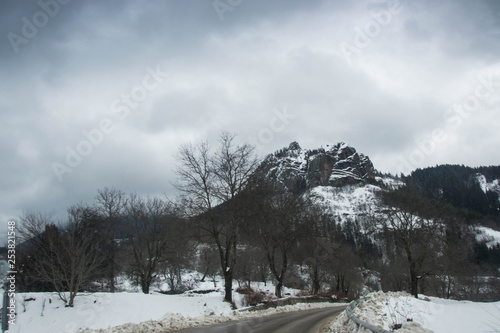 Winter road in winter mountain scene with snow, trees, winter resort Smolyan, Bulgaria, Rhodope Mountains. Road in mountain valley, winter fairy tale