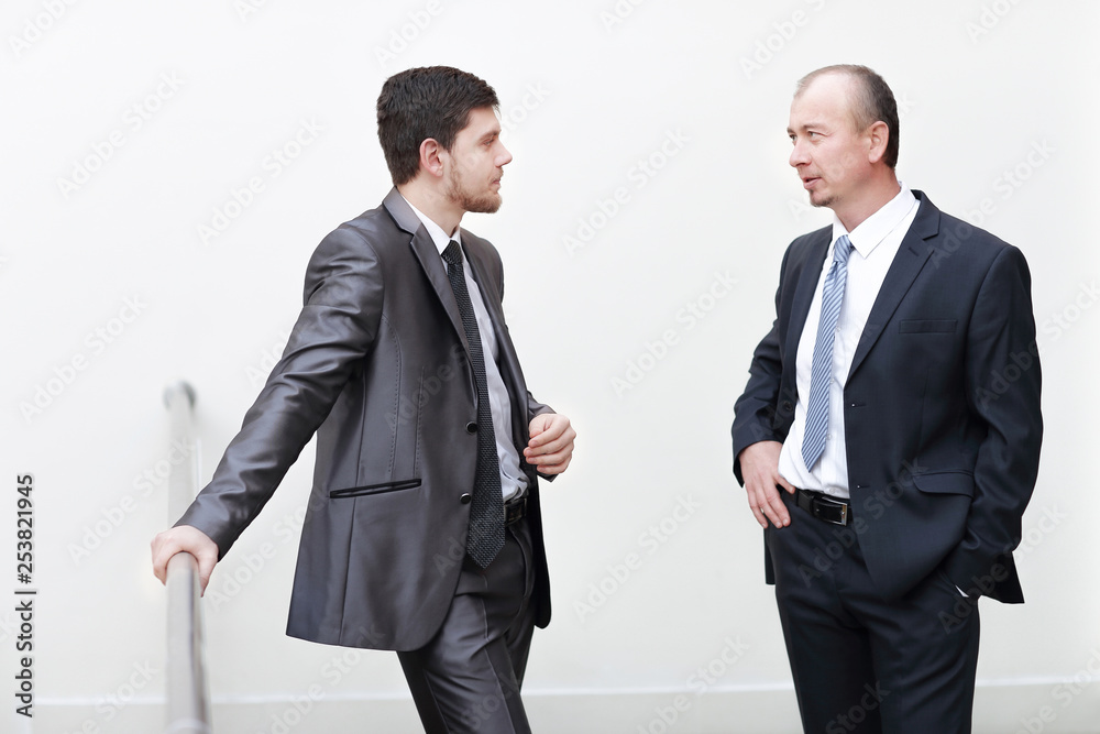 two successful businessman discussing business matters in the lobby of the office. two successful businessman discussing business matters in the lobby of the office.