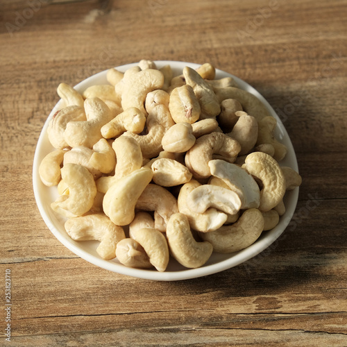 Cashew nuts on a wooden background in a plate. Beautiful nuts on the table