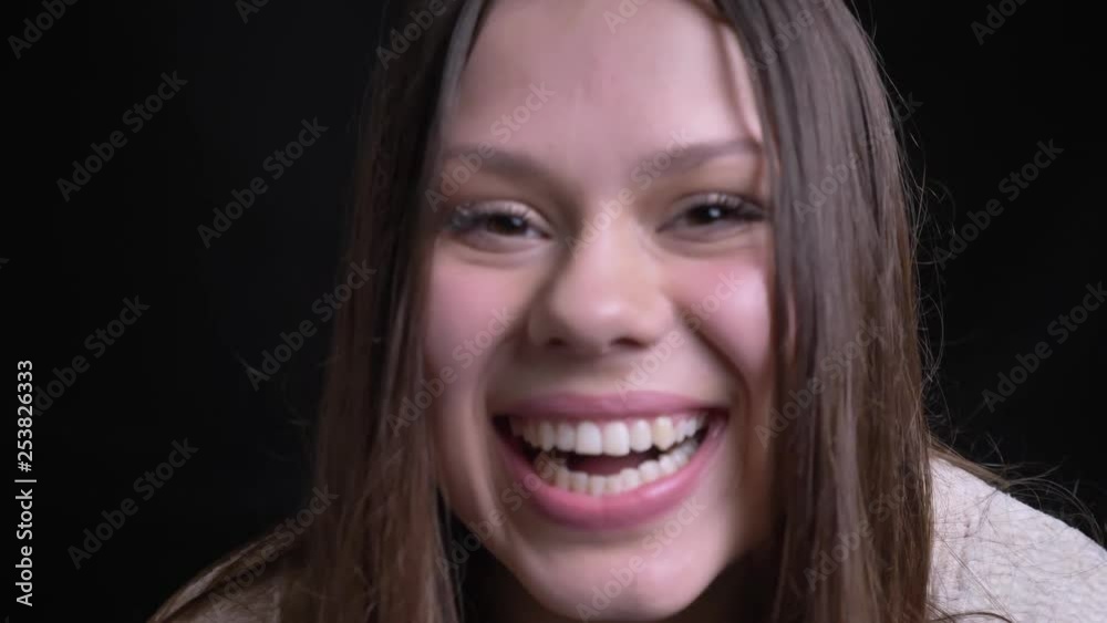 Closeup portrait of adult caucasian female turning to camera and laughing happily with background isolated on black Closeup portrait of adult caucasian female turning to camera and laughing happily with background isolated on black