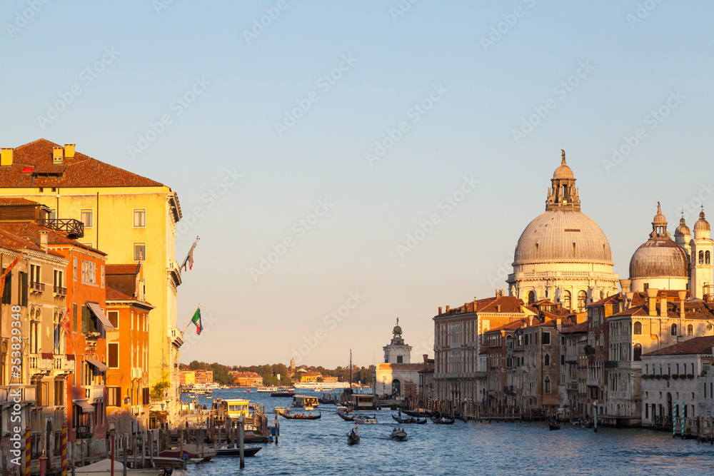 Colorful orange sunset Basilica di Santa Maria della Salute and the Grand Canal, Venice, Veneto, Italy with evening boat traffic