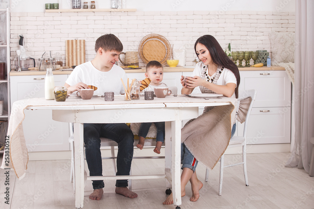 Adorable family cooking togrther. Young family in the kitchen having breakfast or dinner. Mom, dad and their little child preparing meal. Adorable family cooking togrther. Young family in the kitchen having breakfast or dinner. Mom, dad and their little child preparing meal.