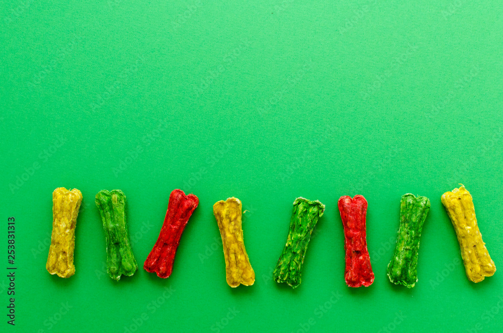 colored chewing bones on greeen background colored chewing bones on greeen background