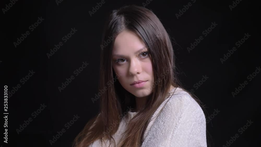 Closeup shoot of young pretty caucasian female with long brunette hair looking at camera with background isolated on black Closeup shoot of young pretty caucasian female with long brunette hair looking at camera with background isolated on black