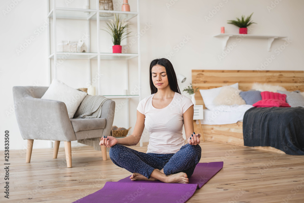 Young adult female doing yoga and smiling at home Young adult female doing yoga and smiling at home