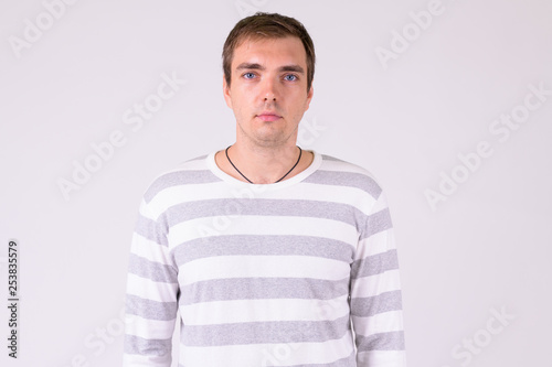 Portrait of man looking at camera against white background