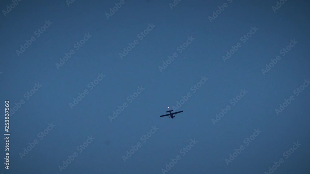 Close up of a small plane flying over a city at night. Close up of a small plane flying over a city at night.