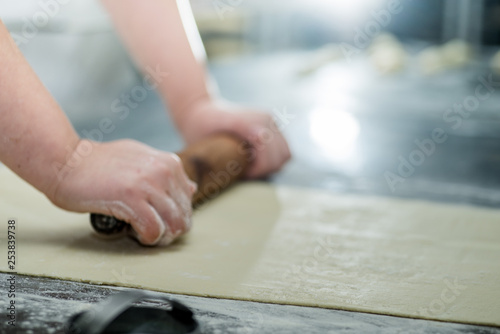 baker's female hands rolling dough