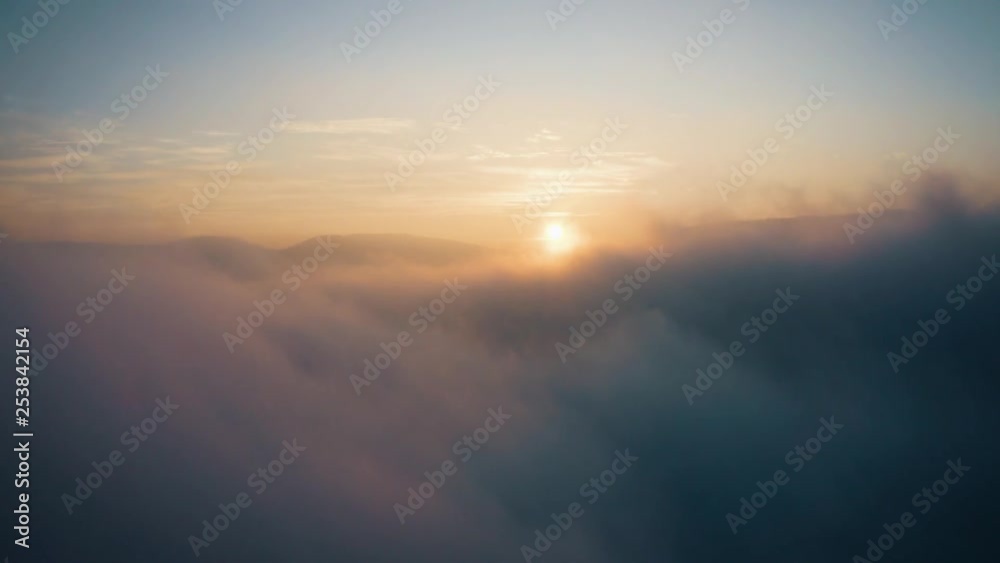 Rising above clouds at sunset with clouds and mystic fog, aerial drone shot Rising above clouds at sunset with clouds and mystic fog, aerial drone shot