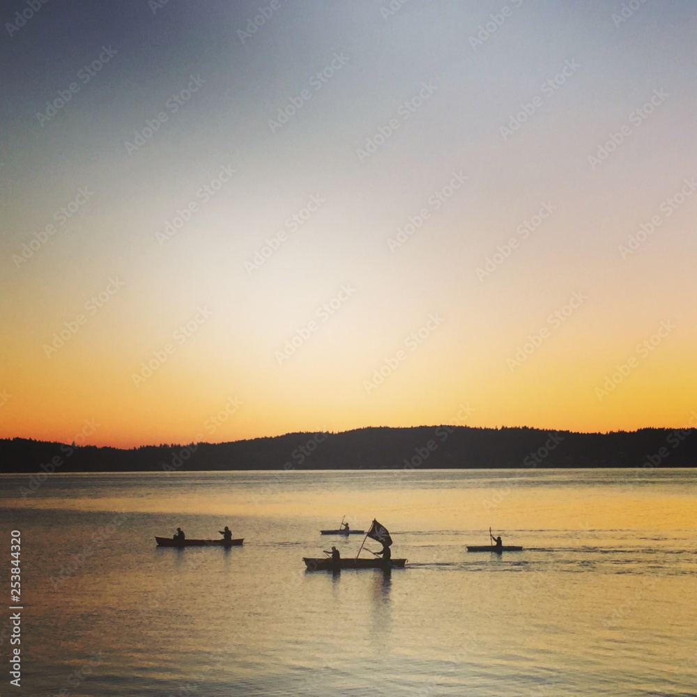 Silhouetted Canoes at Sunset on Puget Sound, WA