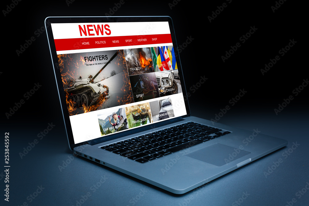 technology, internet, media, business and modern life concept- close up of open laptop computer with news web page on screen and coffee cup on table at office or hotel room