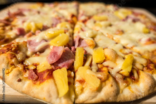 Close up view of a ham and pineapple Hawaiian pizza