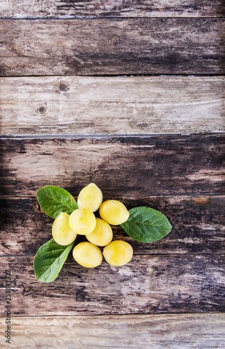 Yellow plums. Fresh ripe sweet fruits on old wooden boards rough background