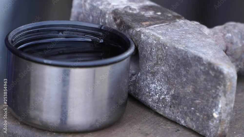 Hammer on the anvil and a cup of tea close-up Hammer on the anvil and a cup of tea close-up