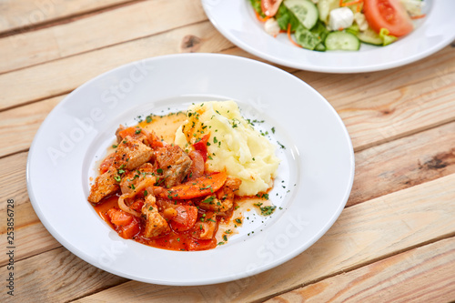 chicken with mashed potatoes and salad on the wooden background