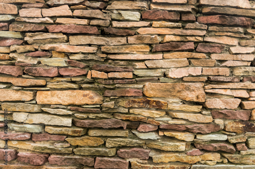 A wall of small stones. Texture of yellow stones. Stony background.